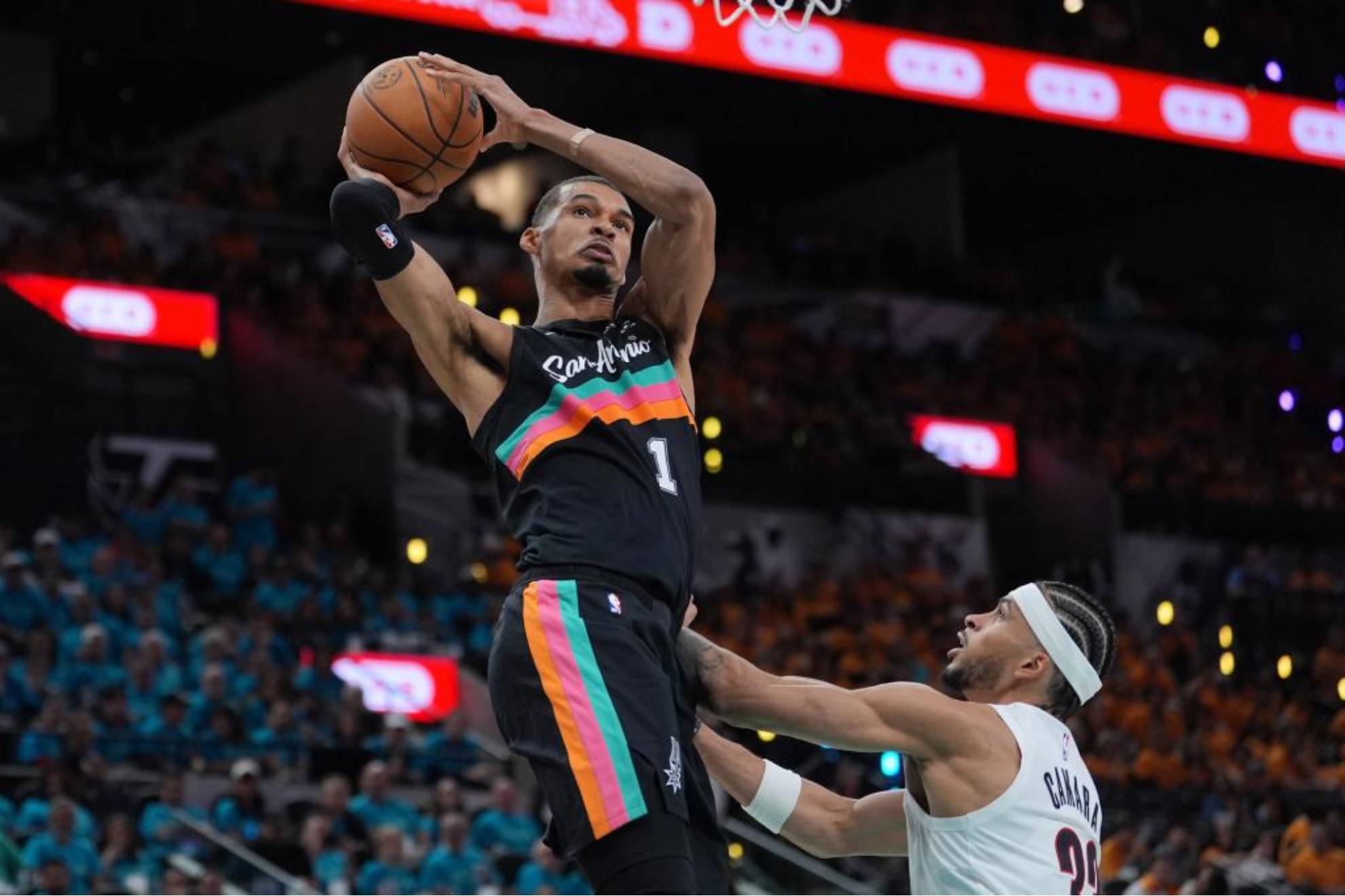 Victor Wembanyama hace una entrada a canasta en presencia de Toumani Camara.