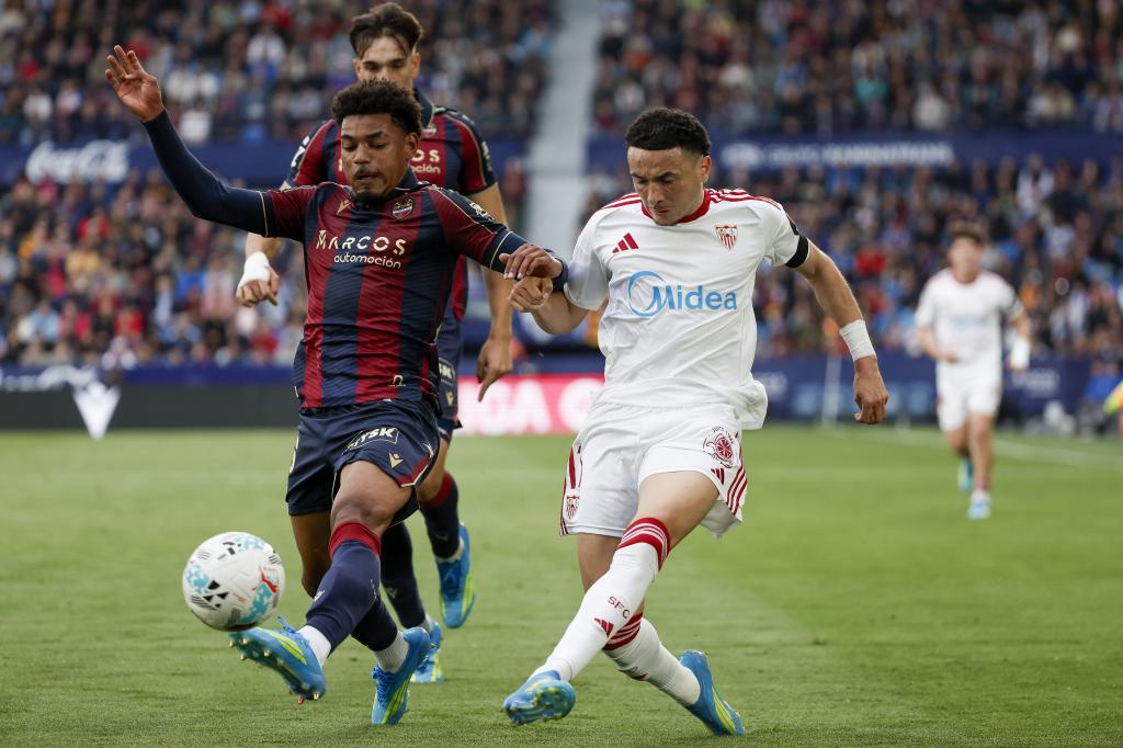 El centrocampista suizo del Sevilla Rubén Vargas (d) pelea un balón con el centrocampista del Levante Kareem Tunde.