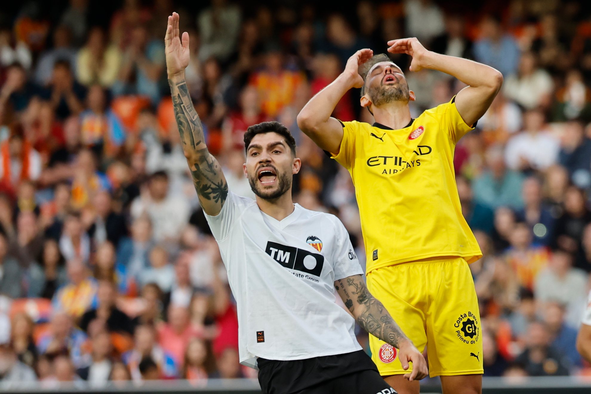 El defensa del Valencia Unai Nuñez (i) y el delantero del Girona Cristhian Stuani.