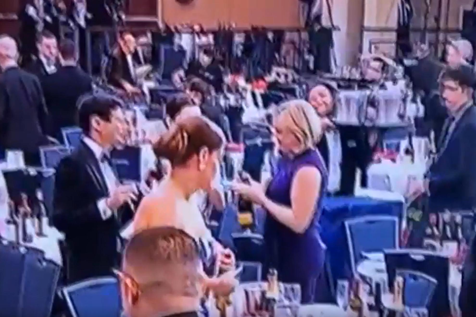 En la imagen, una de las asistentes a la cena de la Asociación de Corresponsales de la Casa Blanca, cogiendo una botella de champán para llevársela.