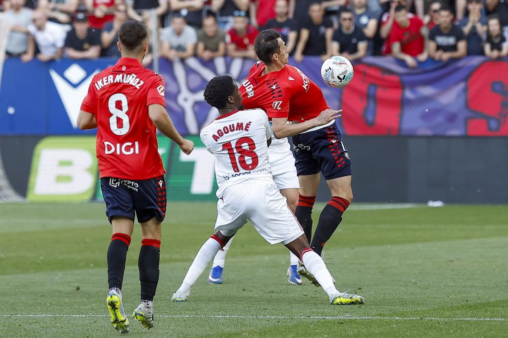 PAMPLONA (ESPAÑA), 26/04/2026.- El centrocampista del Sevilla Lucien Agoume (c) lucha con el croata Ante Budimir (d), de Osasuna, durante el partido de la jornada 32 de LaLiga que Atlético Osasuna y Sevilla FC disputan este domingo en el estadio de El Sadar, en Pamplona. EFE/ Villar López