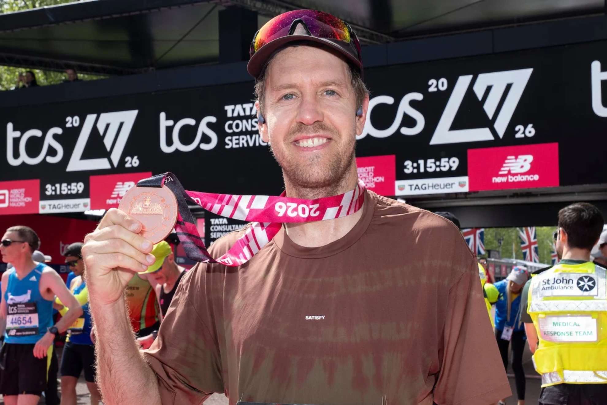 Vettel muestra su medalla tras acabar el Maratón de Londres.
