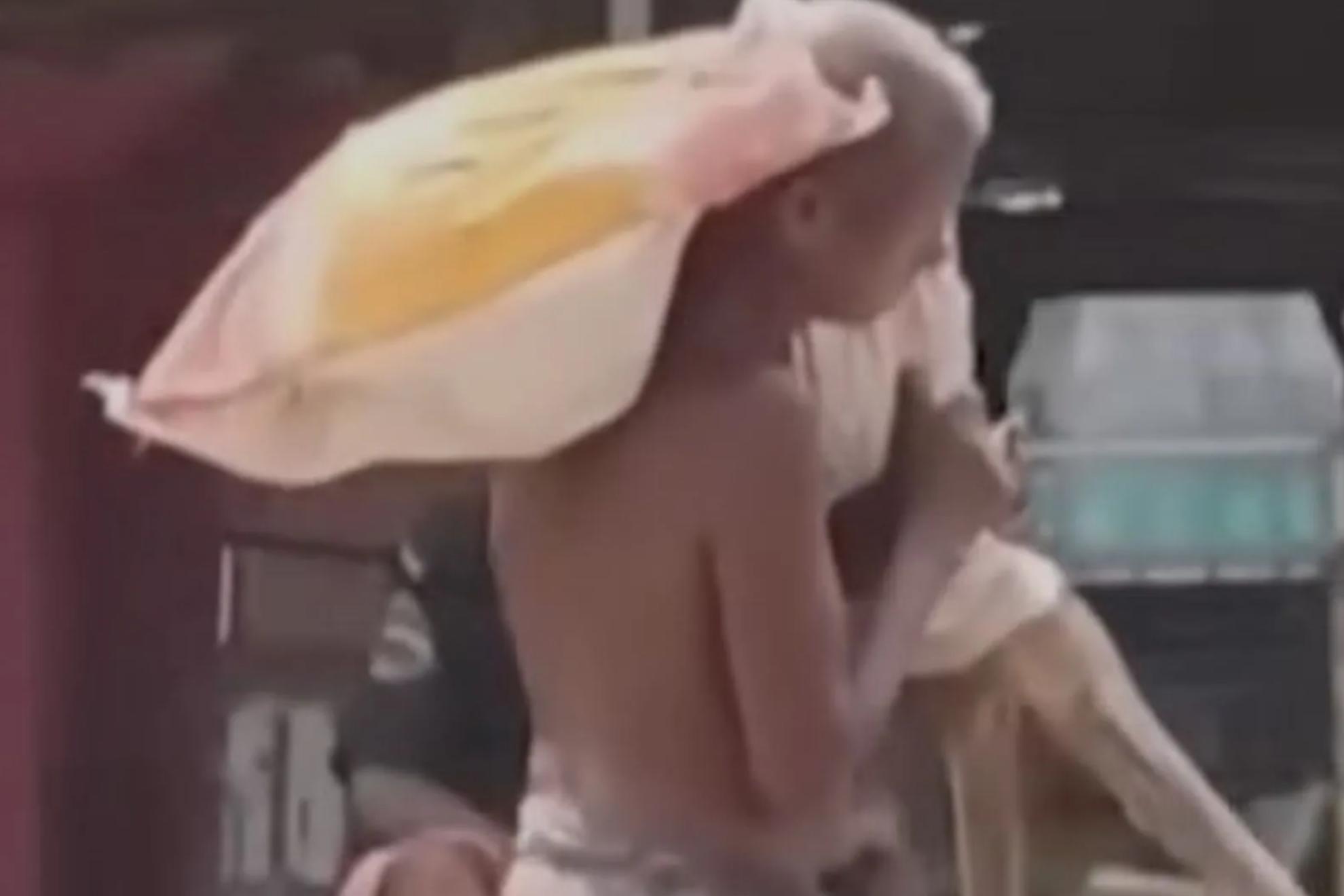 En la imagen, el hombre lleva el cadáver de su hermana en brazos.