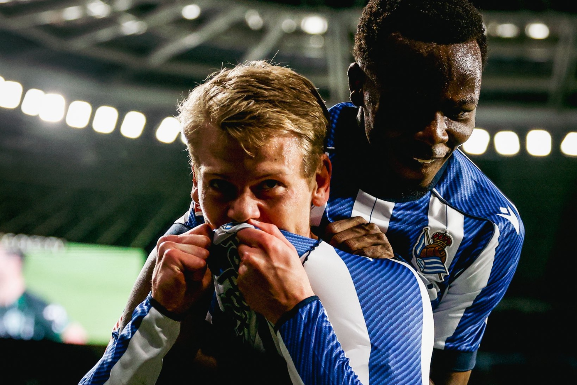 Óskarsson se besa el escudo de la Real tras su gol al Elche, junto a Ochieng.