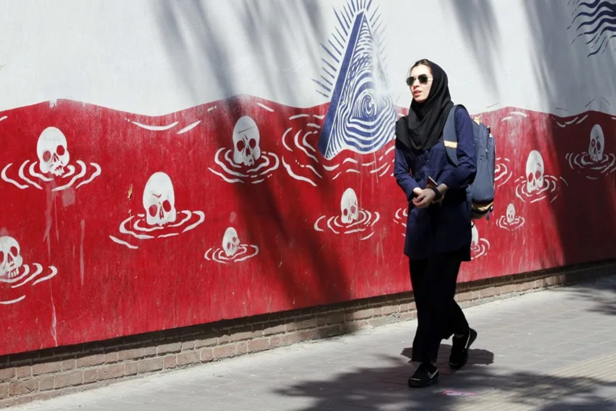 Una mujer iraní camina junto a un mural antiestadounidense cerca de la antigua embajada de Estados Unidos en Teherán.