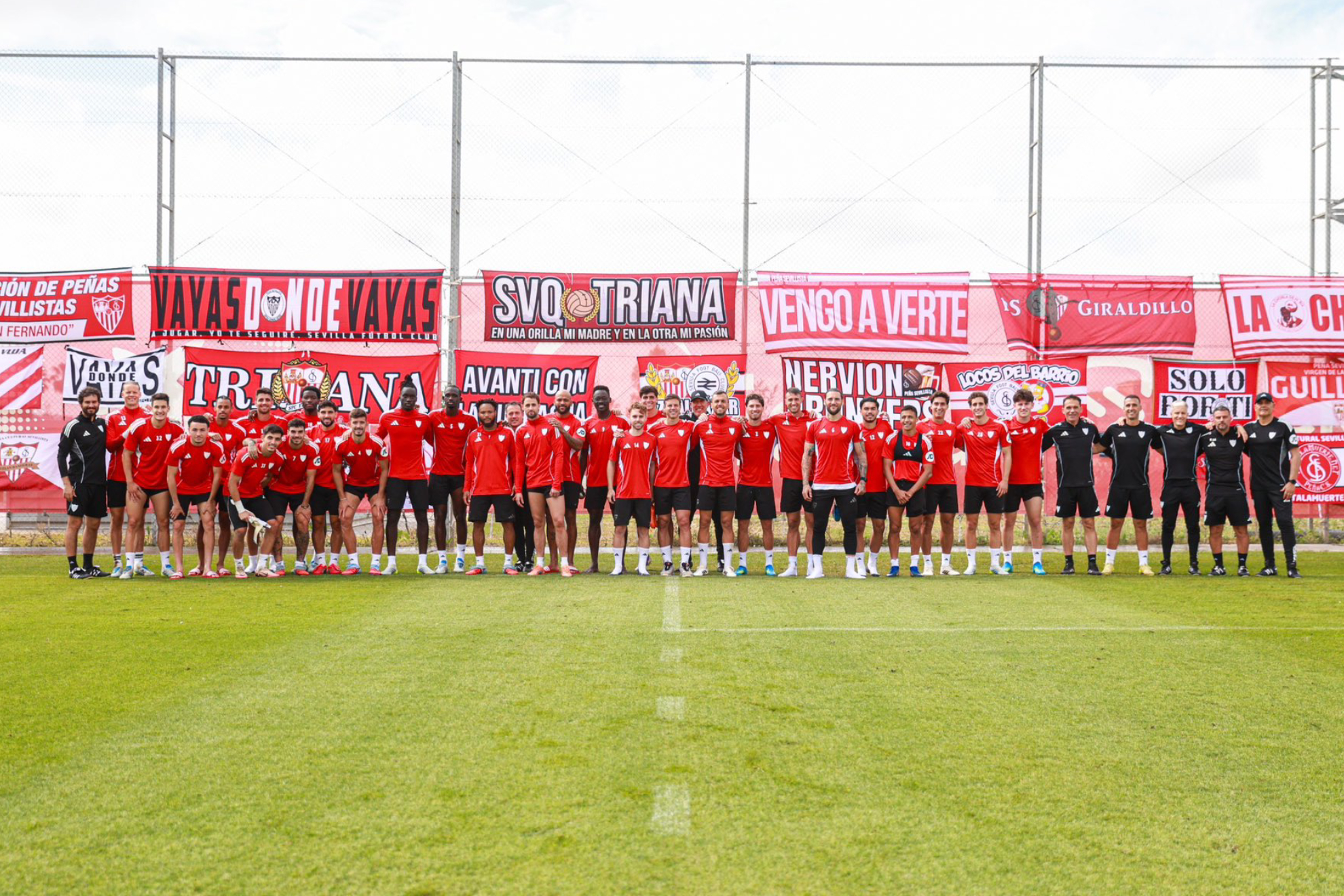 Plantilla y cuerpo técnico posan en la ciudad deportiva ante las pancartas  y las banderas de las peñas.