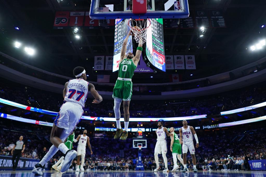 Jayson Tatum crushes the rim while VJ Edgecombe looks on.