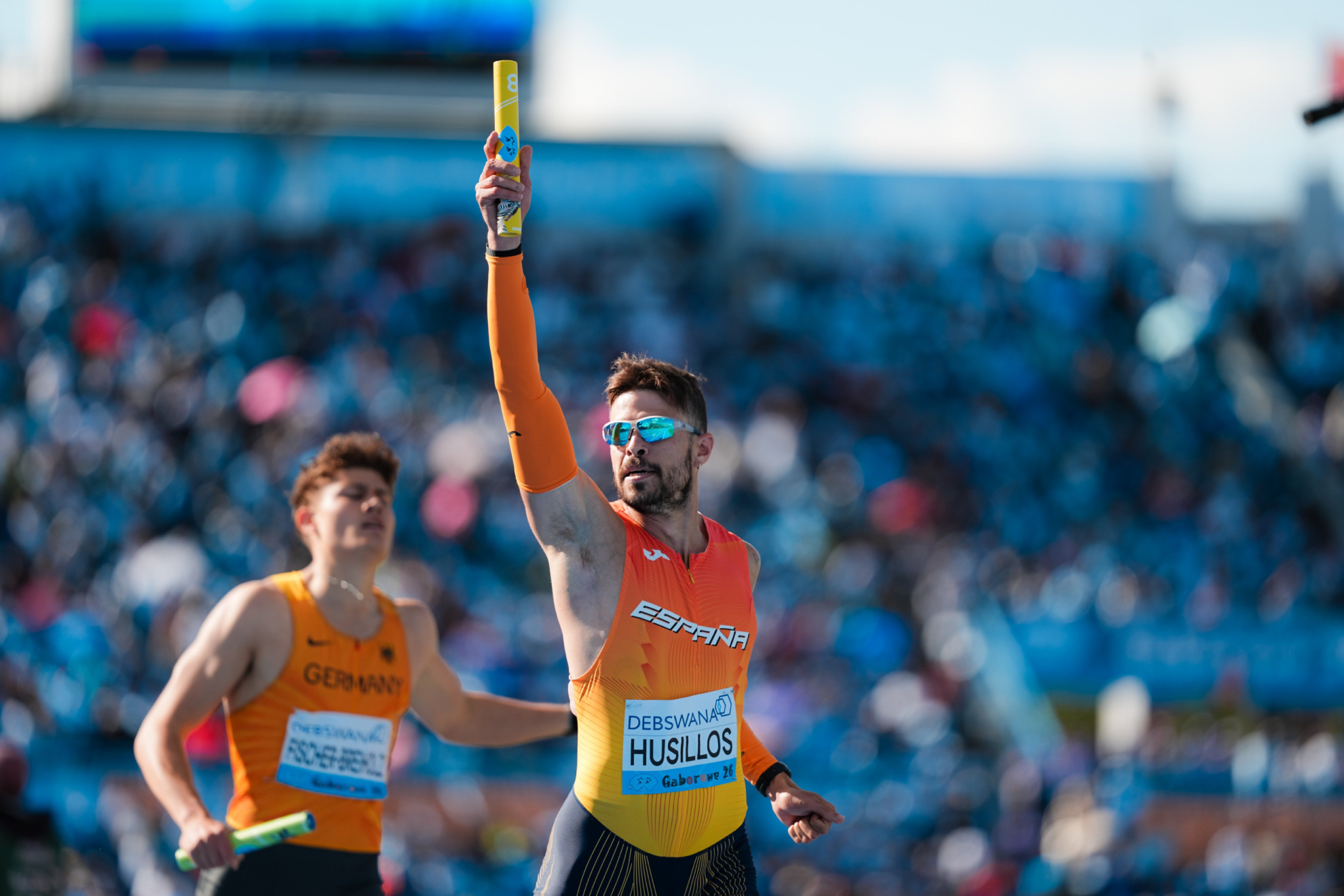 Óscar Husillos celebra la clasificación con el testigo en alto tras cruzar la línea de meta.