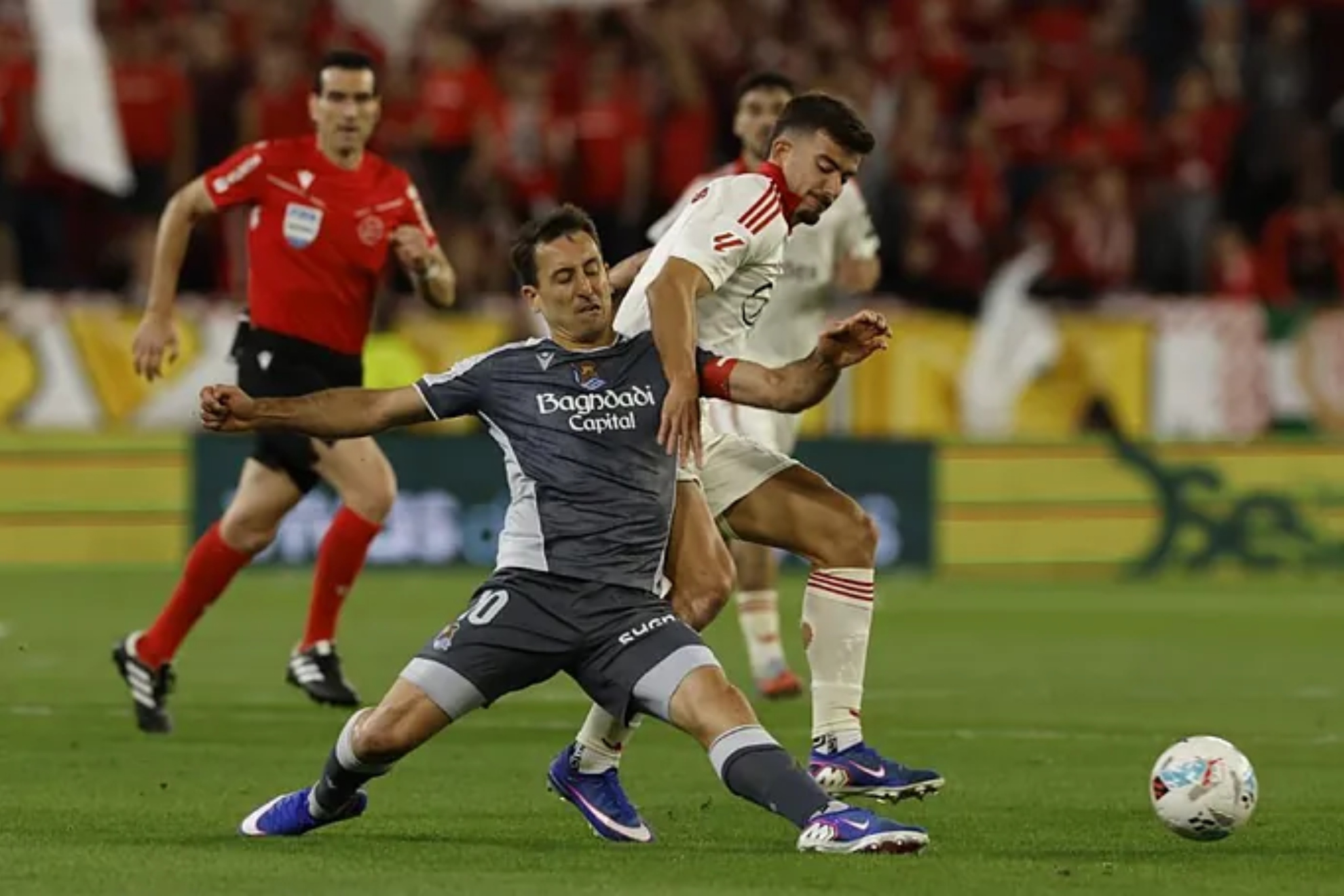 Mikel Oyarzabal disputa un balón con el jugador del Sevilla Kike Salas.
