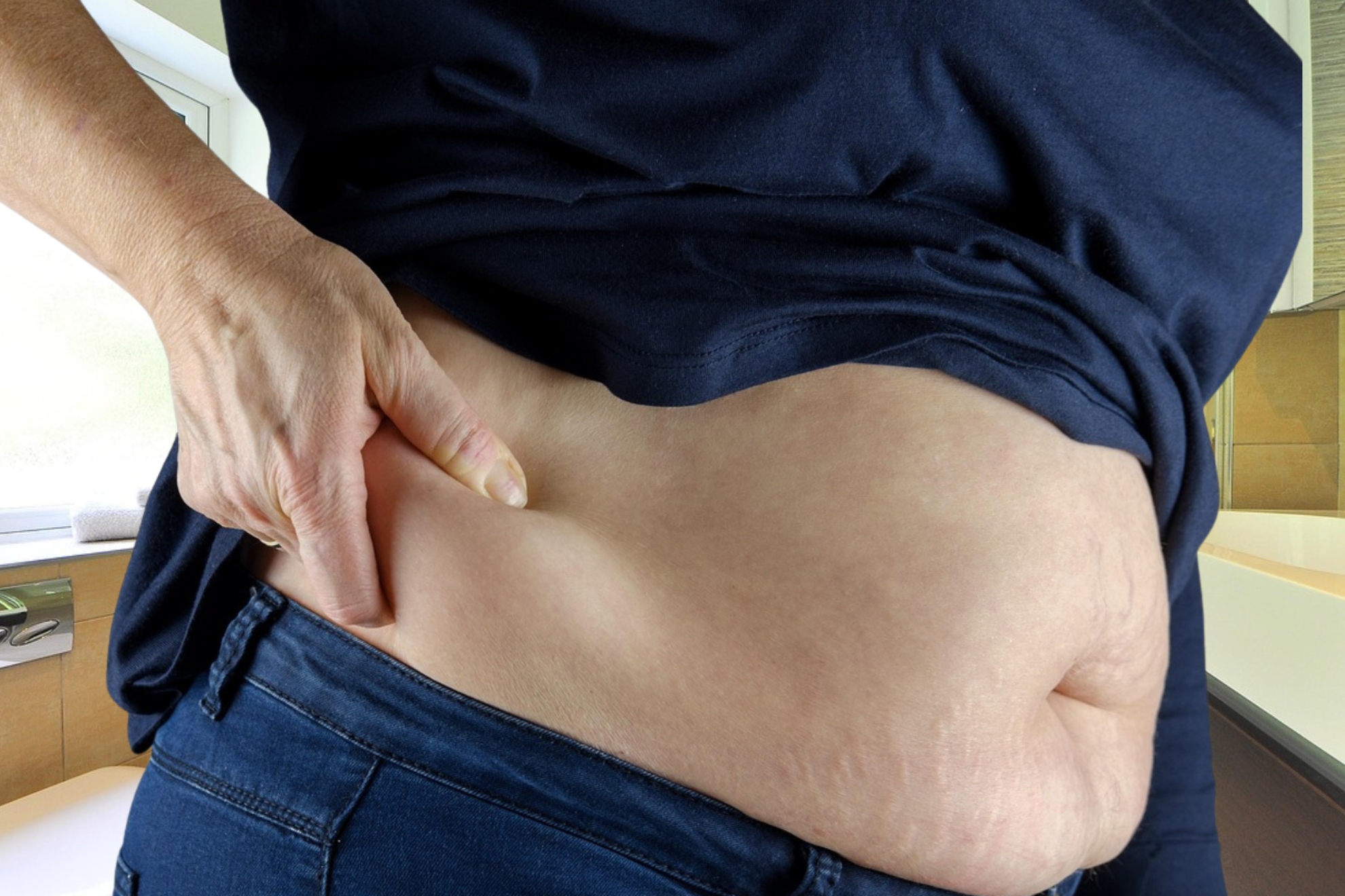Imagen de una persona llevándose la mano a su lado derecho abdominal.