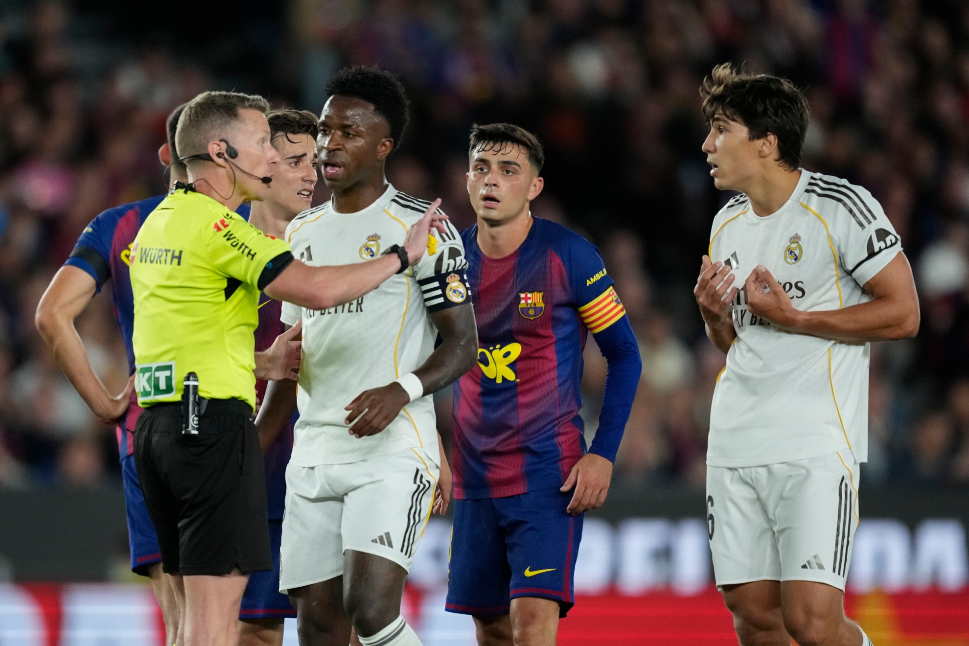 El colegiado, Hernández Hernández, se dirige a Gonzalo con Vinicius delante.