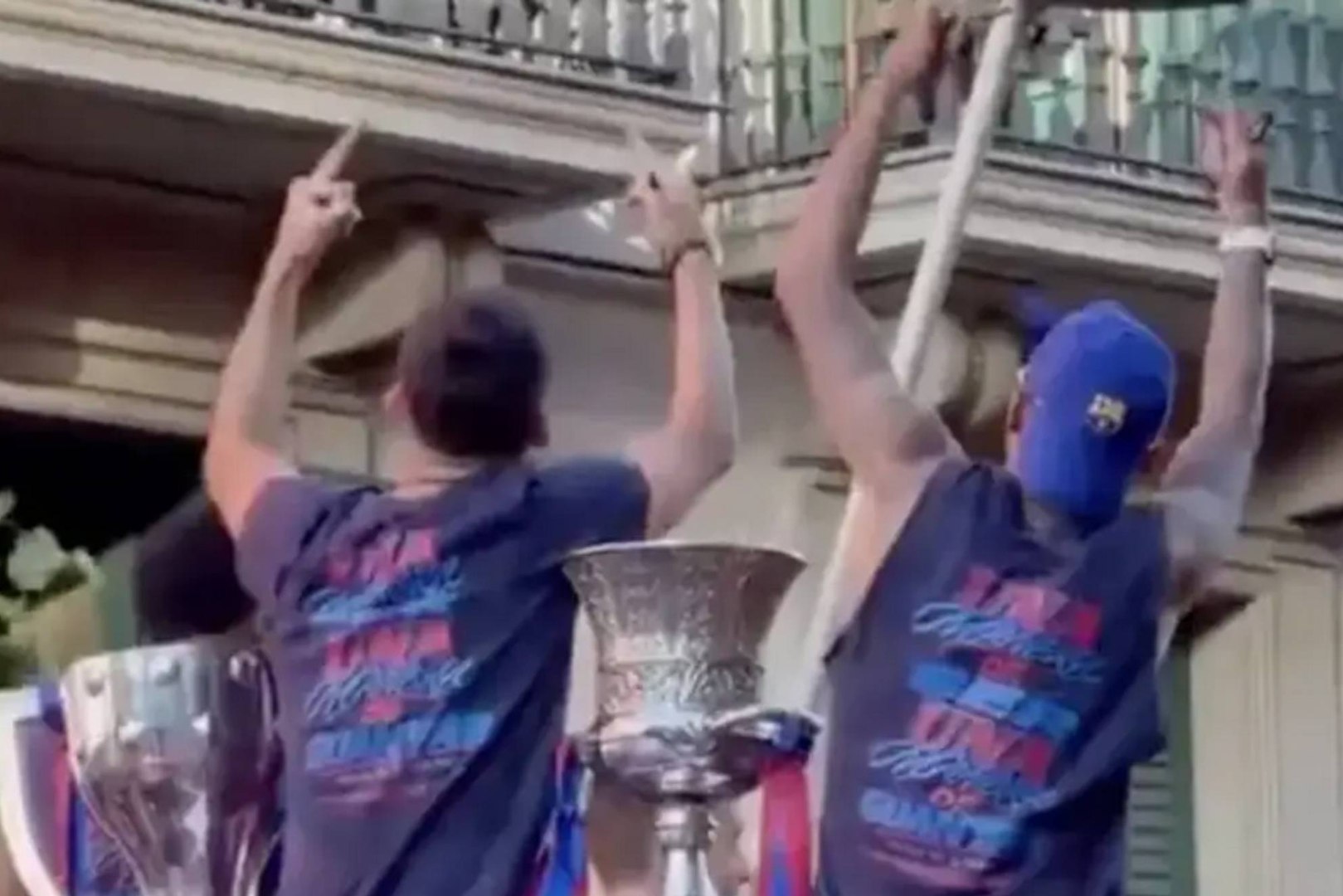Raphinha y Gerard Martín, jugadores del F.C. Barcelona, le realizaron un gesto obsceno a un aficionado que salió al balcón con una camiseta del Real Madrid durante la rúa del Barça para celebrar su título liguero.