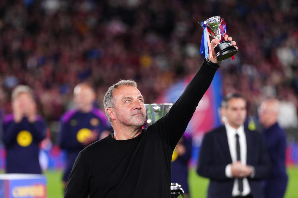 El entrenador del Barcelona Hansi Flick levanta su premio después de que el equipo conquistó La Liga con una victoria ante el Real Madrid el domingo 10 de mayo del 2026. (AP Foto/Joan Mateu Parra)