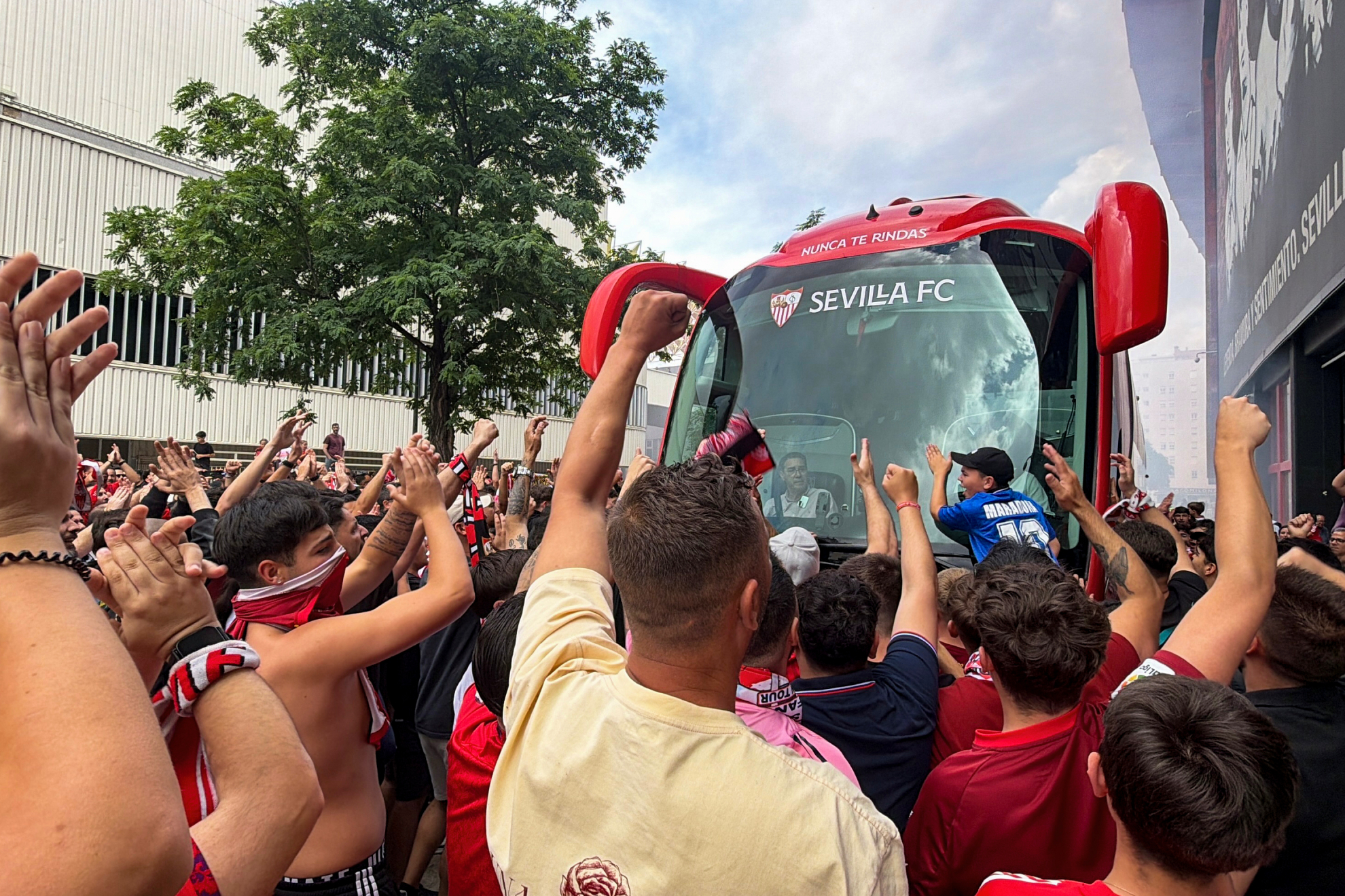 Aficionados del Sevilla animan a los jugadores tras un entrenamiento en el estadio.