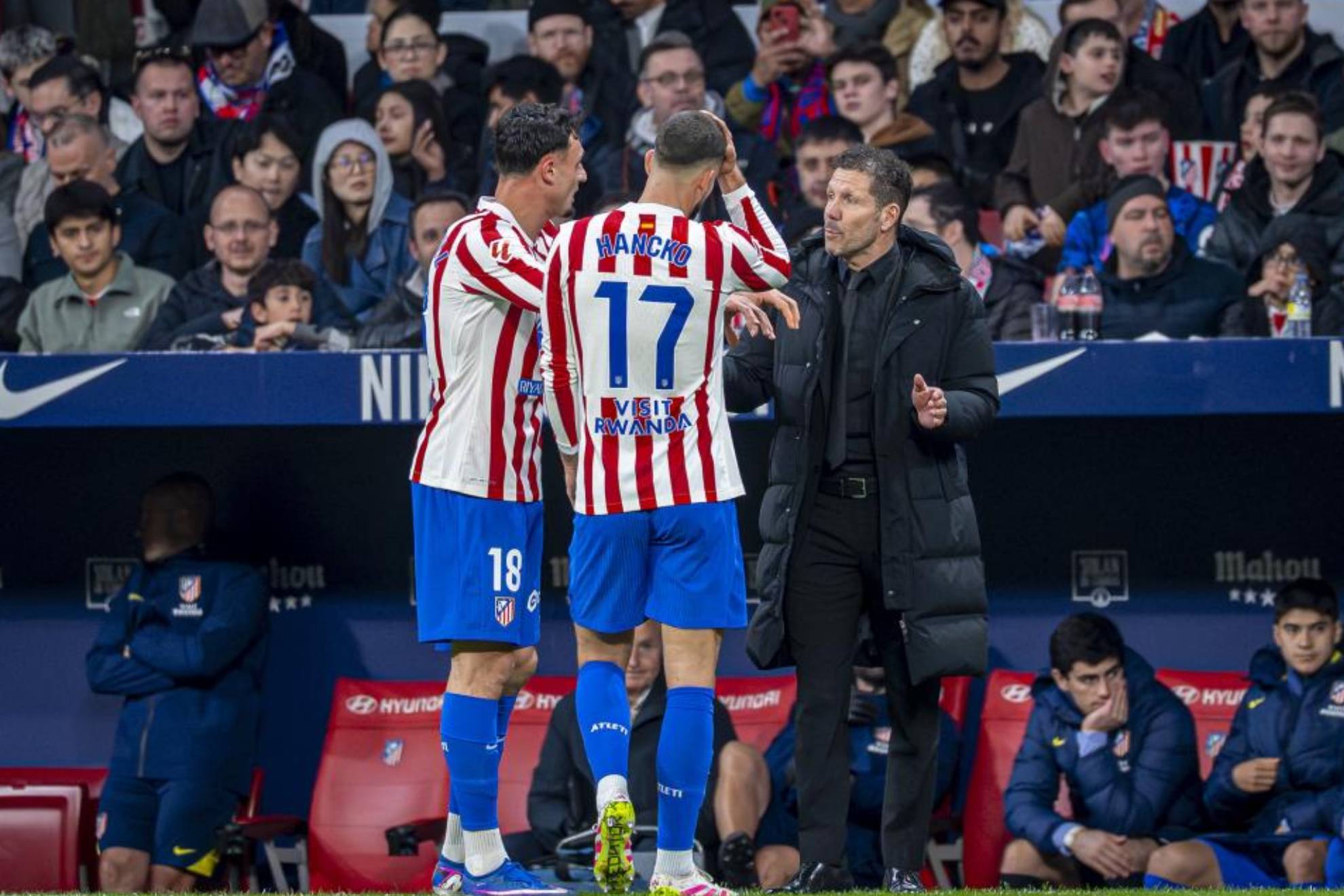Simeone habla con Pubill y Hancko en un partido.