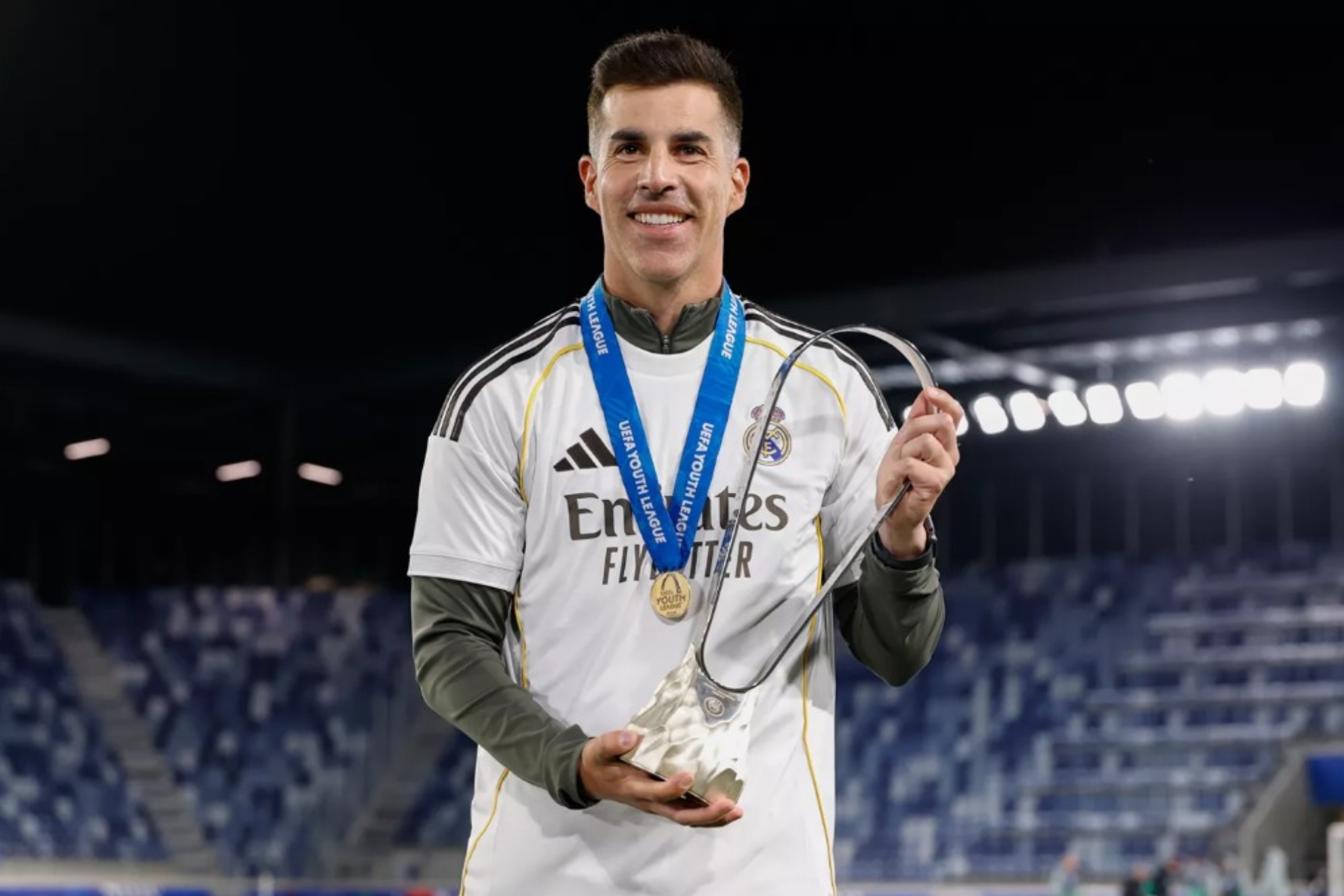 Álvaro López, técnico del Juvenil A del Real Madrid, posa con el trofeo de la Youth League.