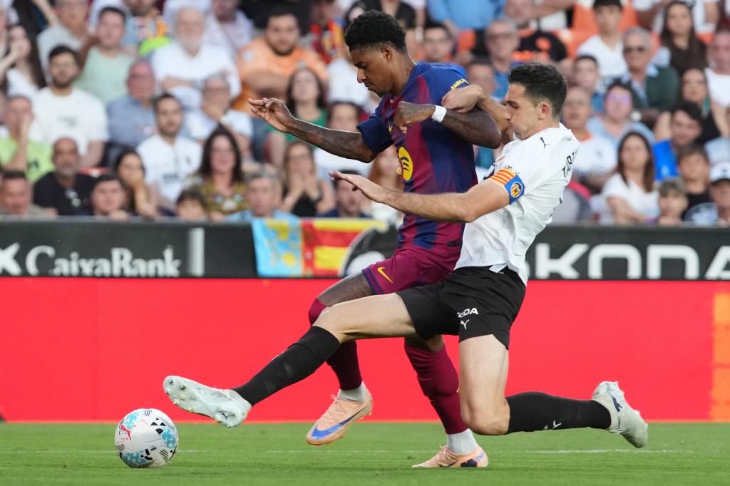 Valencia's Cesar Tarrega, right, pressures Barcelona's Marcus Rashford during the Spanish La Liga soccer match between Valencia and FC Barcelona in Valencia, Spain, Saturday, May 23, 2026. (AP Photo/Alberto Saiz)