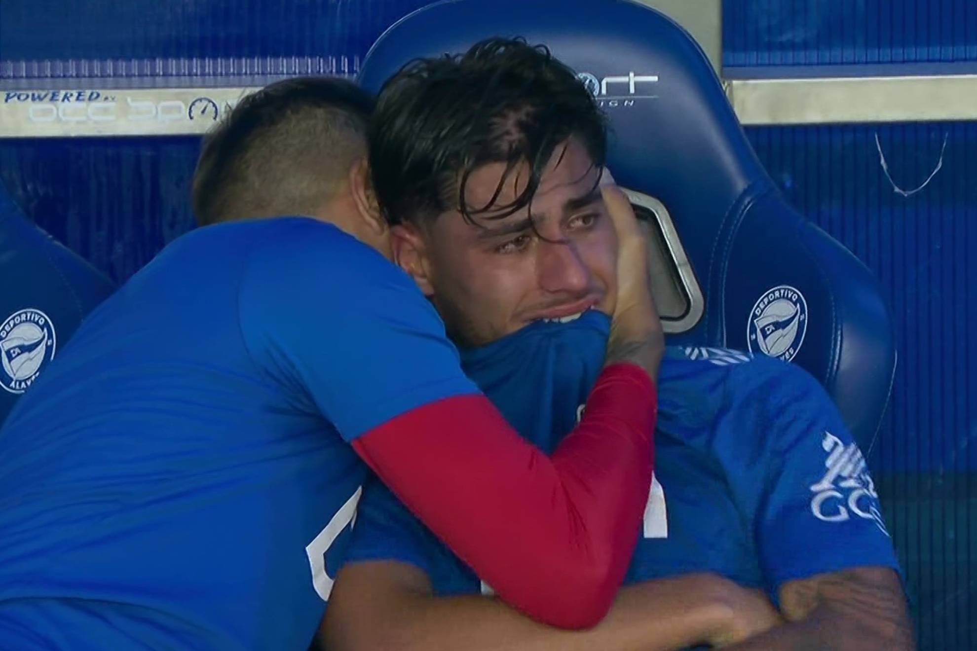 Carlos Martín, siendo consolado por Óscar Trejo en el banquillo.