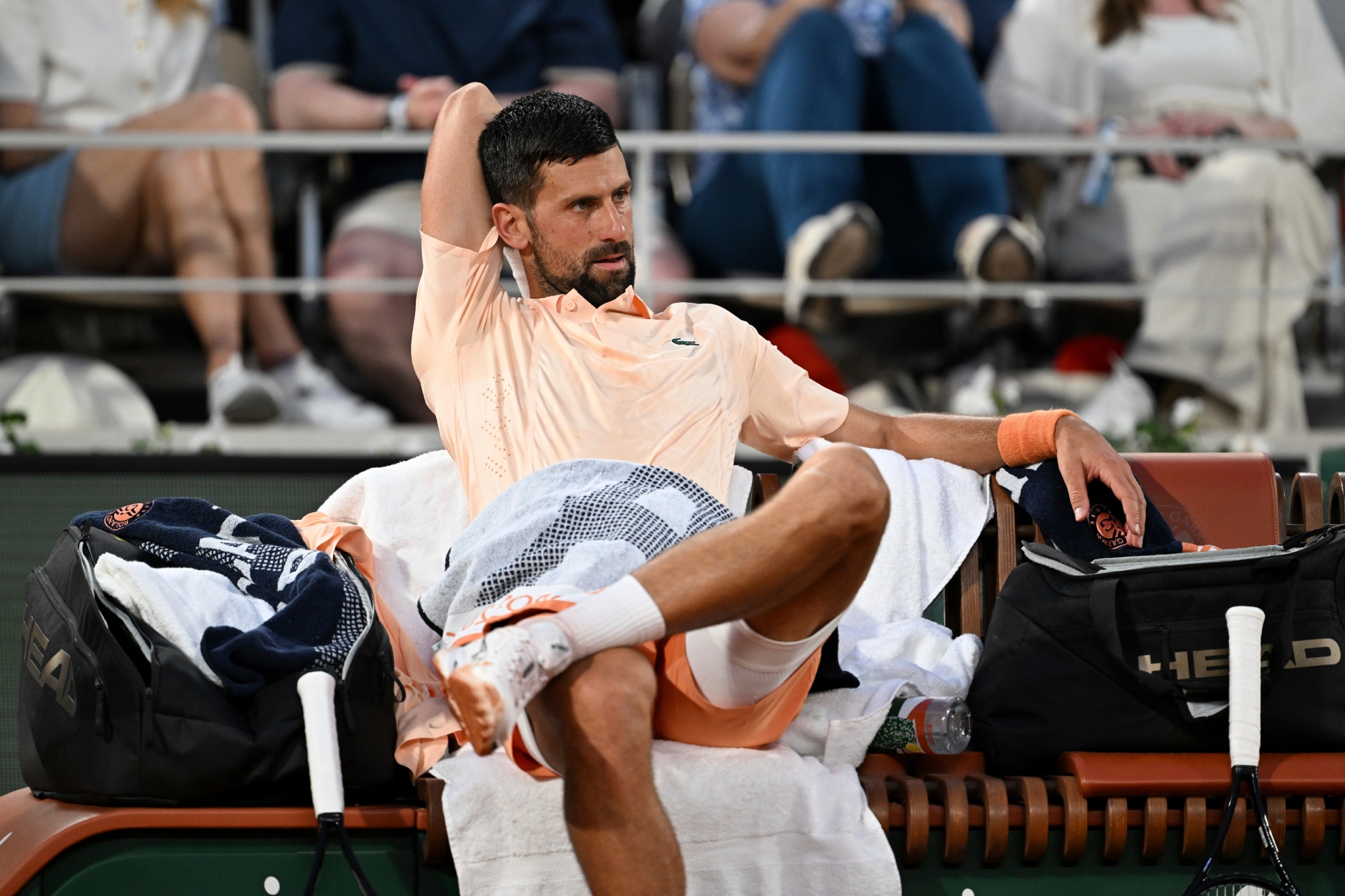 Djokovic hace estiramientos en la silla de cambios,