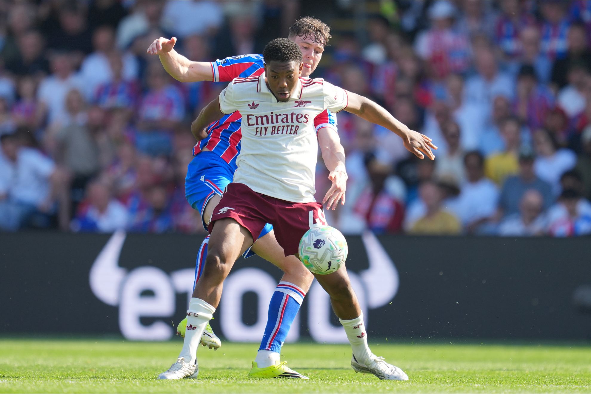 Lewis-Skelly protects the ball against Strand Larsen