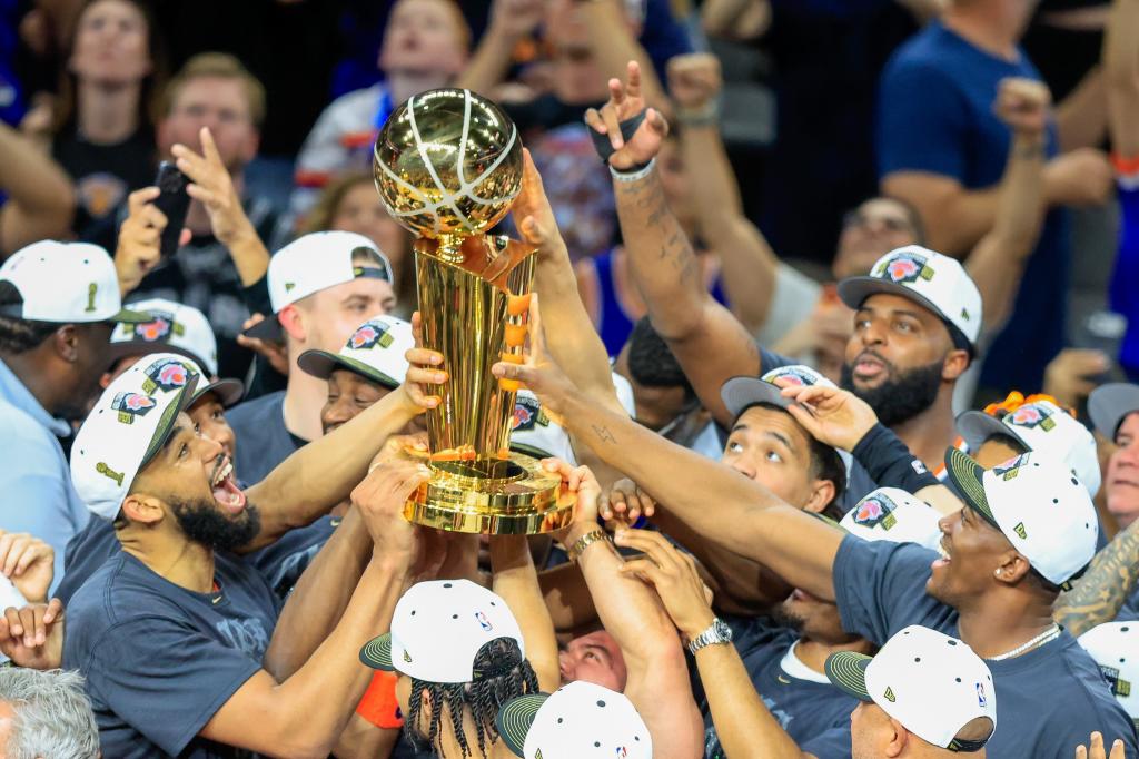 Los jugadores de los NY Knicks levantan el trofeo de campeón de la NBA.
