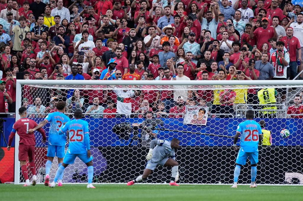 Portugal's Cristiano Ronaldo, left, watches as Congo goalkeeper Lionel Mpasi fails to save the opening goal by Portugal's Joao Neves during the World Cup Group K soccer match between Portugal and Congo in Houston, Wednesday, June 17, 2026. (AP Photo/Ashley Landis)