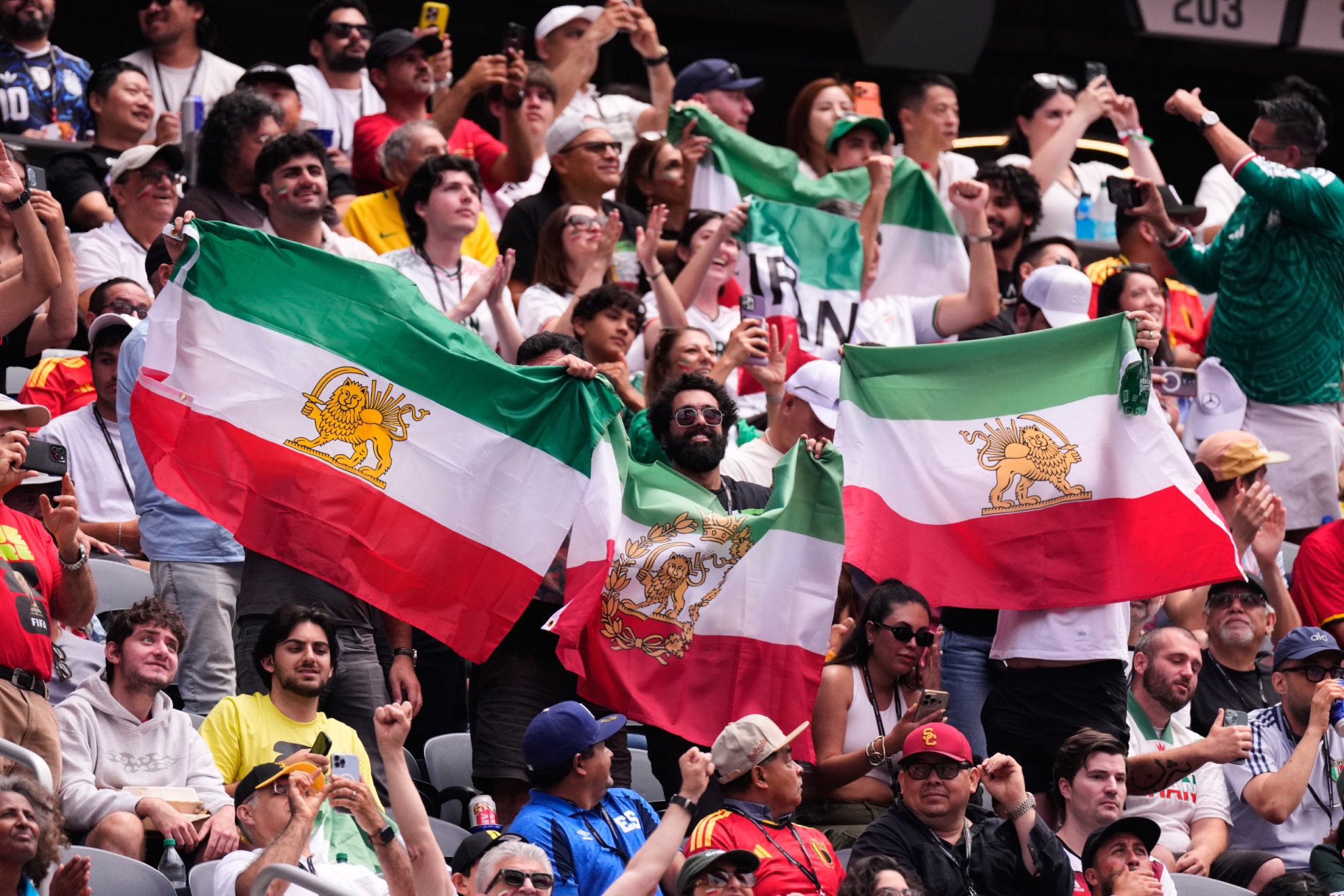 Aficionados iraníes sostienen la bandera prerrevolucionaria de Irán