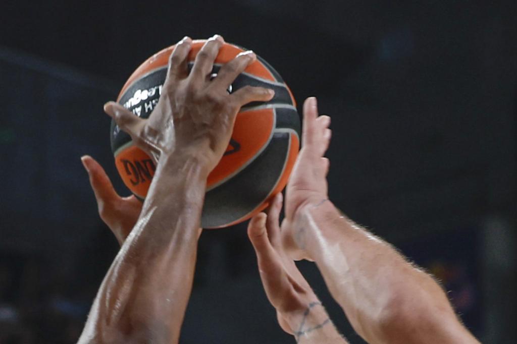 Players fighting for a ball in a Euroleague game.