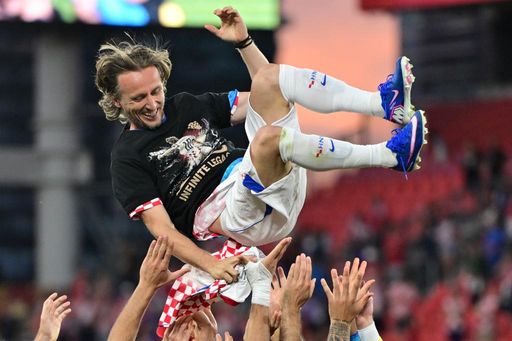 Jogadores croatas jogam Luka Modric para o alto para comemorar sua 200ª partida pela seleção nacional.