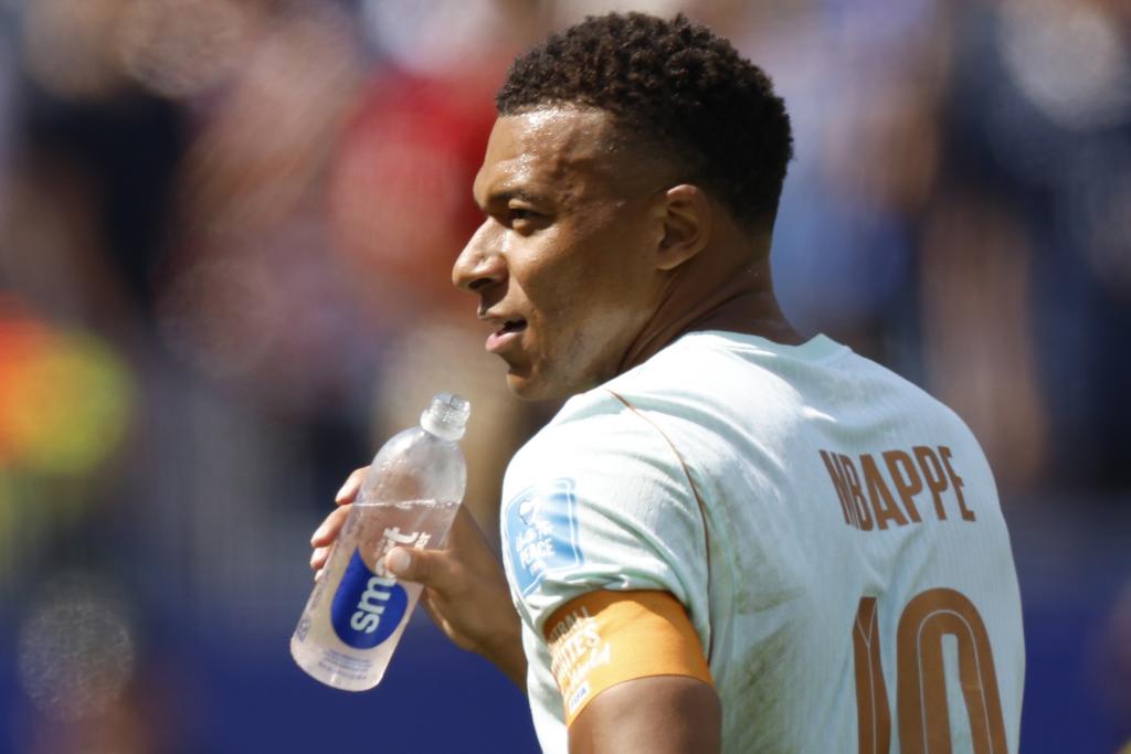 Mbappé bebe agua en un encuentro.