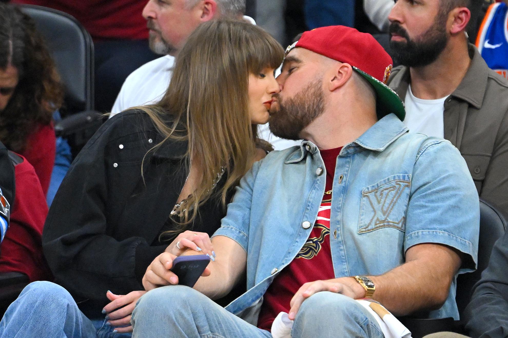 Taylor Swift y Travis Kelce se besan en el Madison Square Garden de Nueva York durante un partido de la NBA