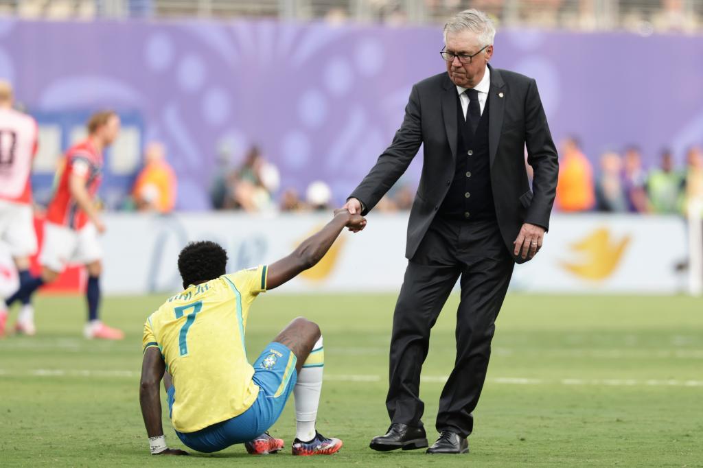 Ancelotti ayuda a Vinicius a levantarse.