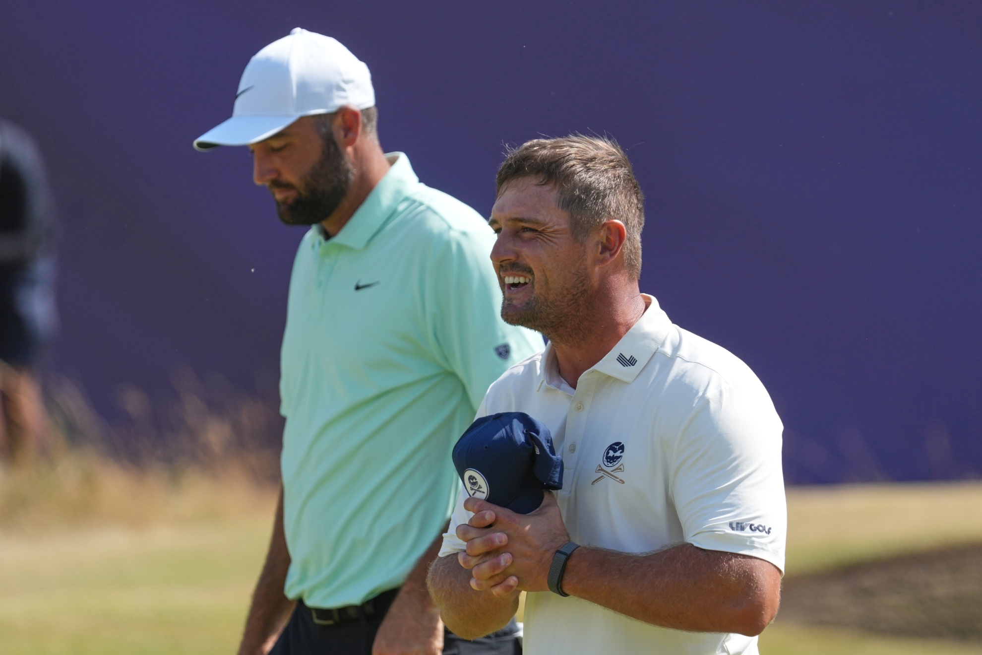 Bryson DeChambeau y Scottie Scheffler en el green del 18 tras acabar la primera ronda.