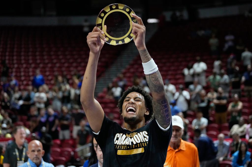 Yaxel Lendeborg eleva el trofeo de MVP ganado en el partido.