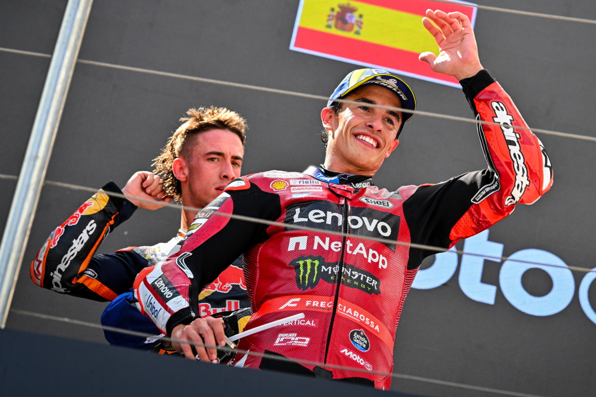 Marc Márquez saluda en el podio, con Pedro Acosta detrás suya.