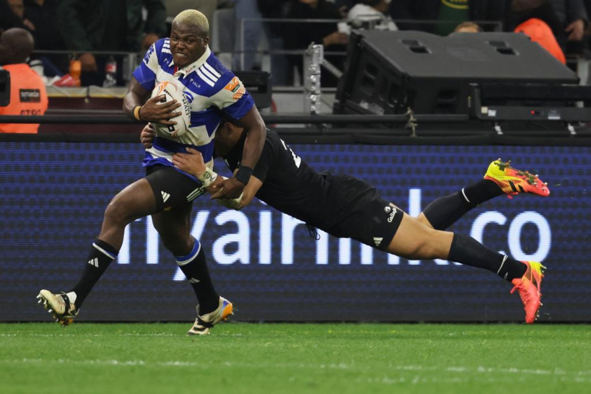 Hacjivah Dayimani, de Stormers, es placado por Caleb Clarke. AP Photo/Halden Krog