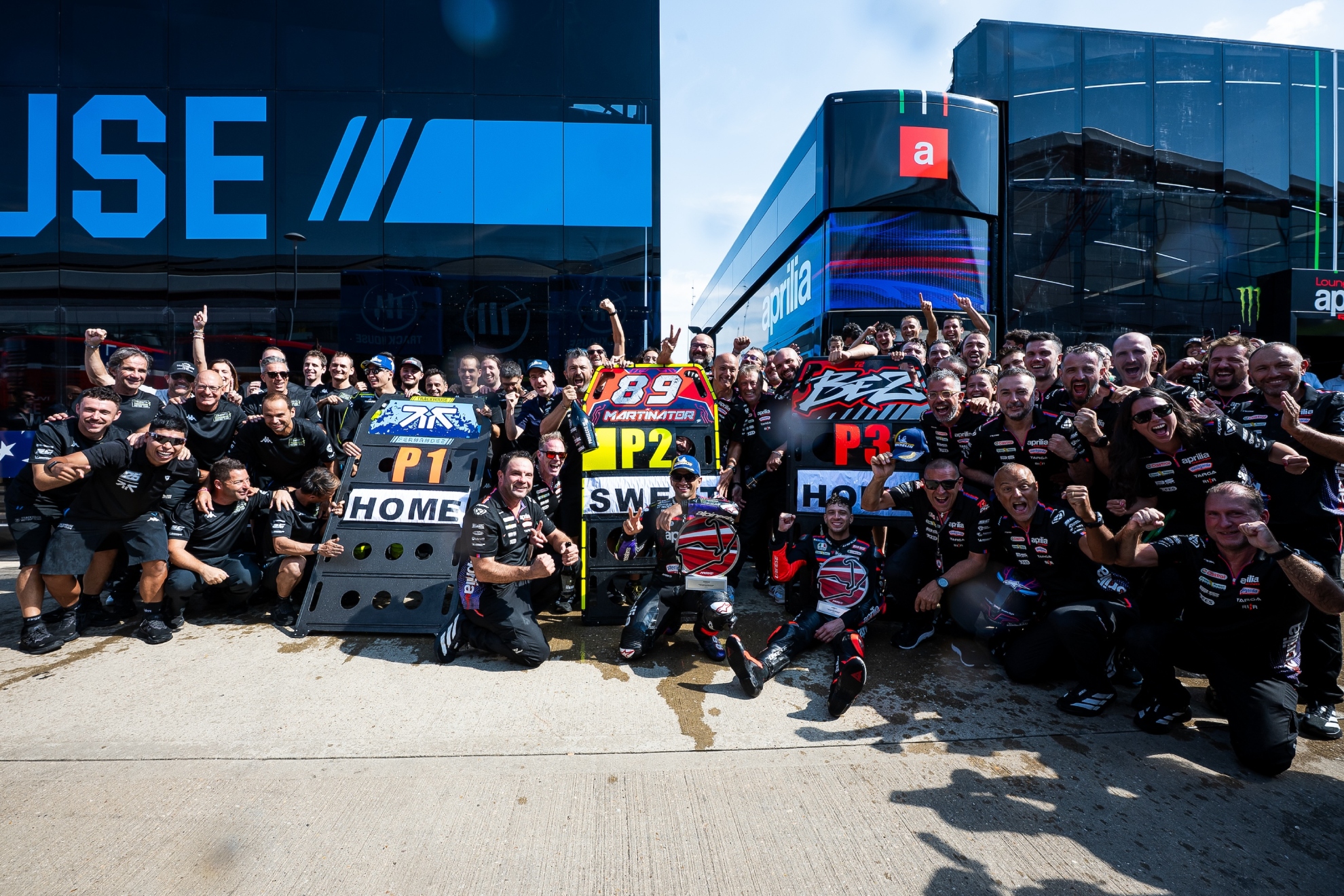 Los equipos de Raúl Fernández, Jorge Martín y Bezzecchi celebran el triplete. APRILIA