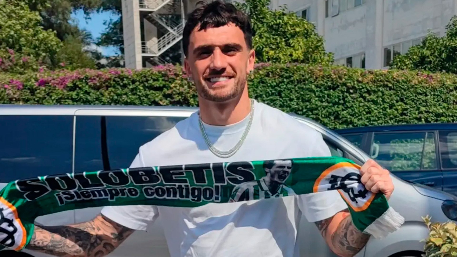 Parrott posa con una bufanda del Betis a su llegada al aeropuerto.