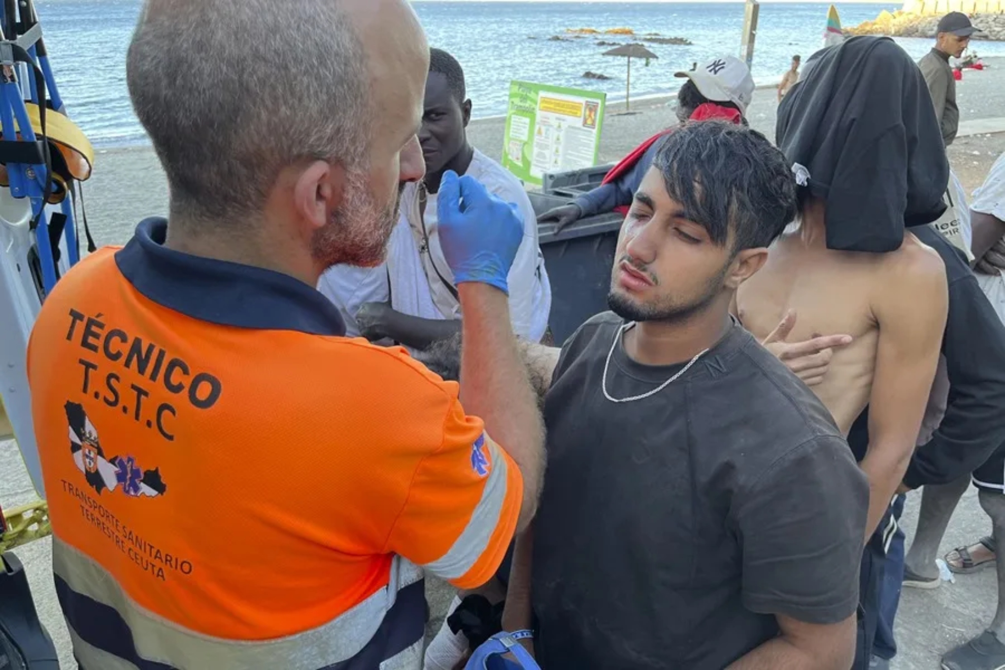 Imagen de recurso de un profesional de la Cruz Roja atendiendo a un migrante en Ceuta. EFE