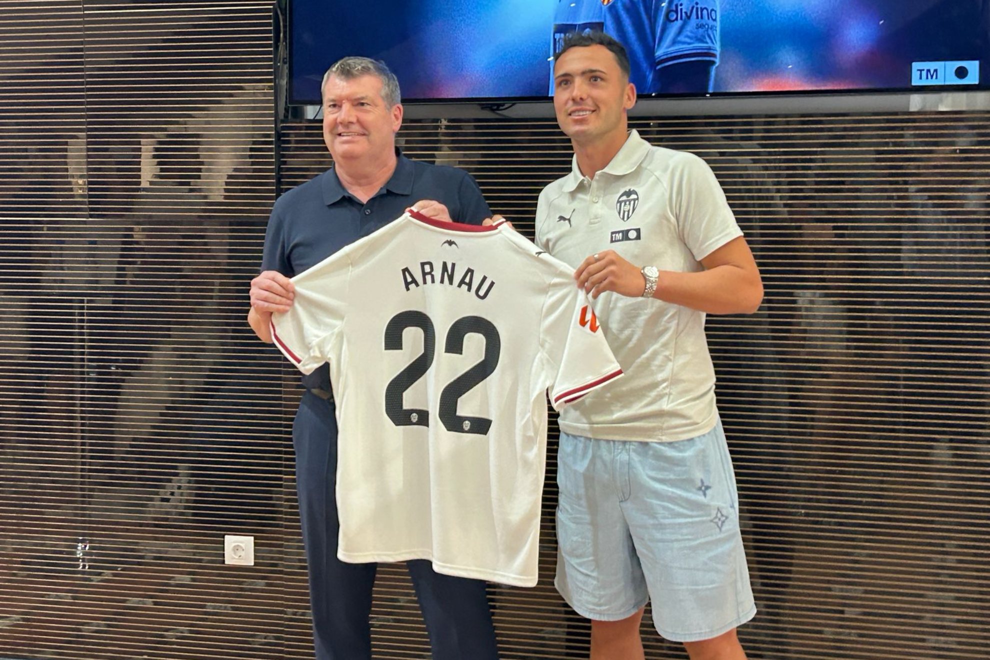 Arnau Martínez posa con la camiseta del Valencia junto a Ron Gourlay, CEO de Fútbol.