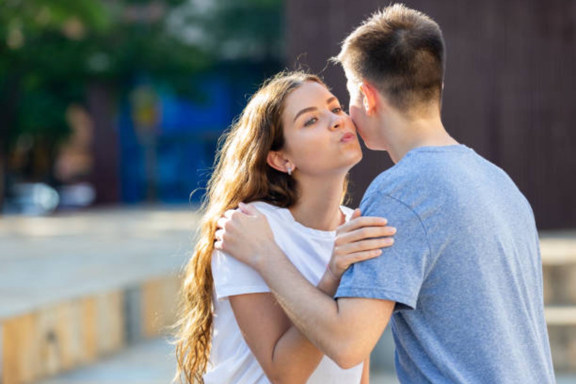 Imagen de un chico y una chica saludándose con dos besos.