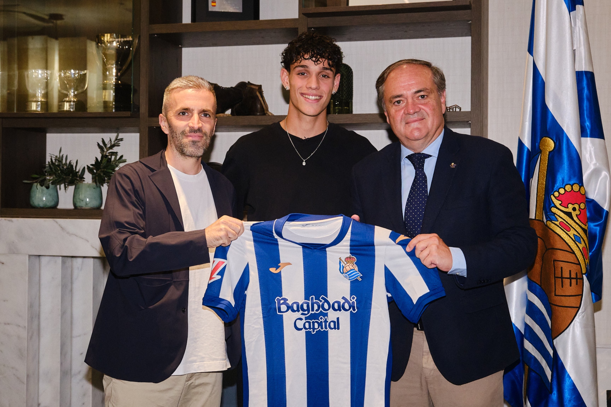 Héctor Fort posa sonriente con Erik Bretos y Jokin Aperribay, tras firmar con la Real. REAL SOCIEDAD