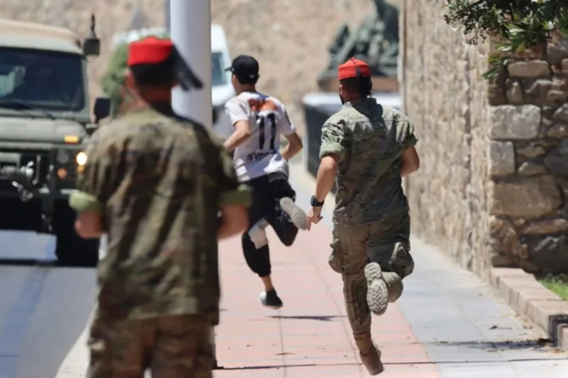Imagen de recurso de dos militares corriendo tras un migrante en Ceuta.