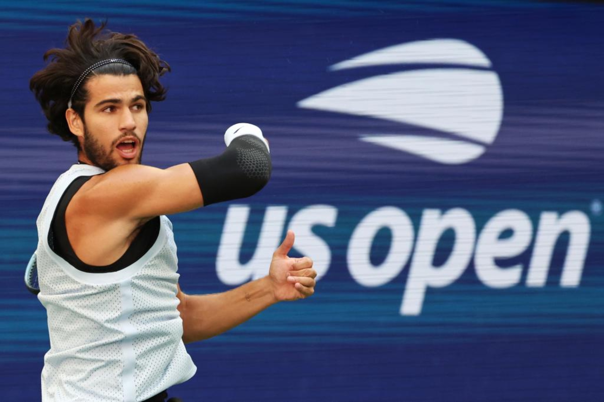 Alcaraz golpea una bola frente al logotipo del US Open