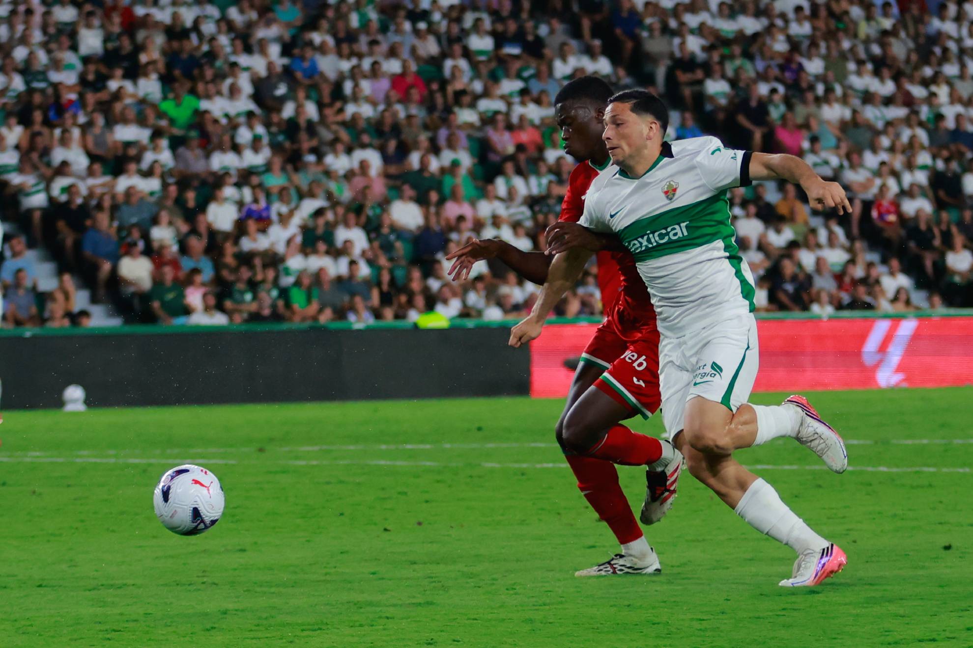Mamadou Sarr disputa el balón ante el delantero argentino del Elche, Abiel Osorio. EFE