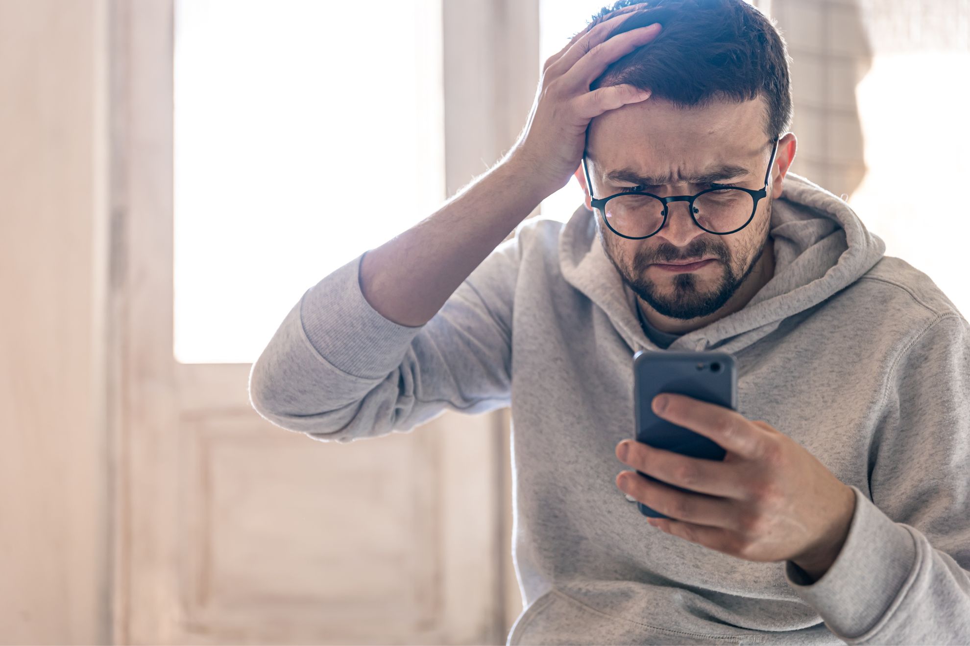 Un hombre, reaccionando con su teléfono móvil.