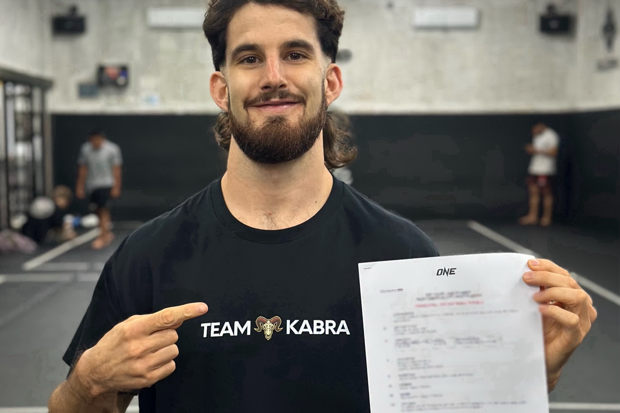 Javi Cabrera posa con el contrato con ONE.