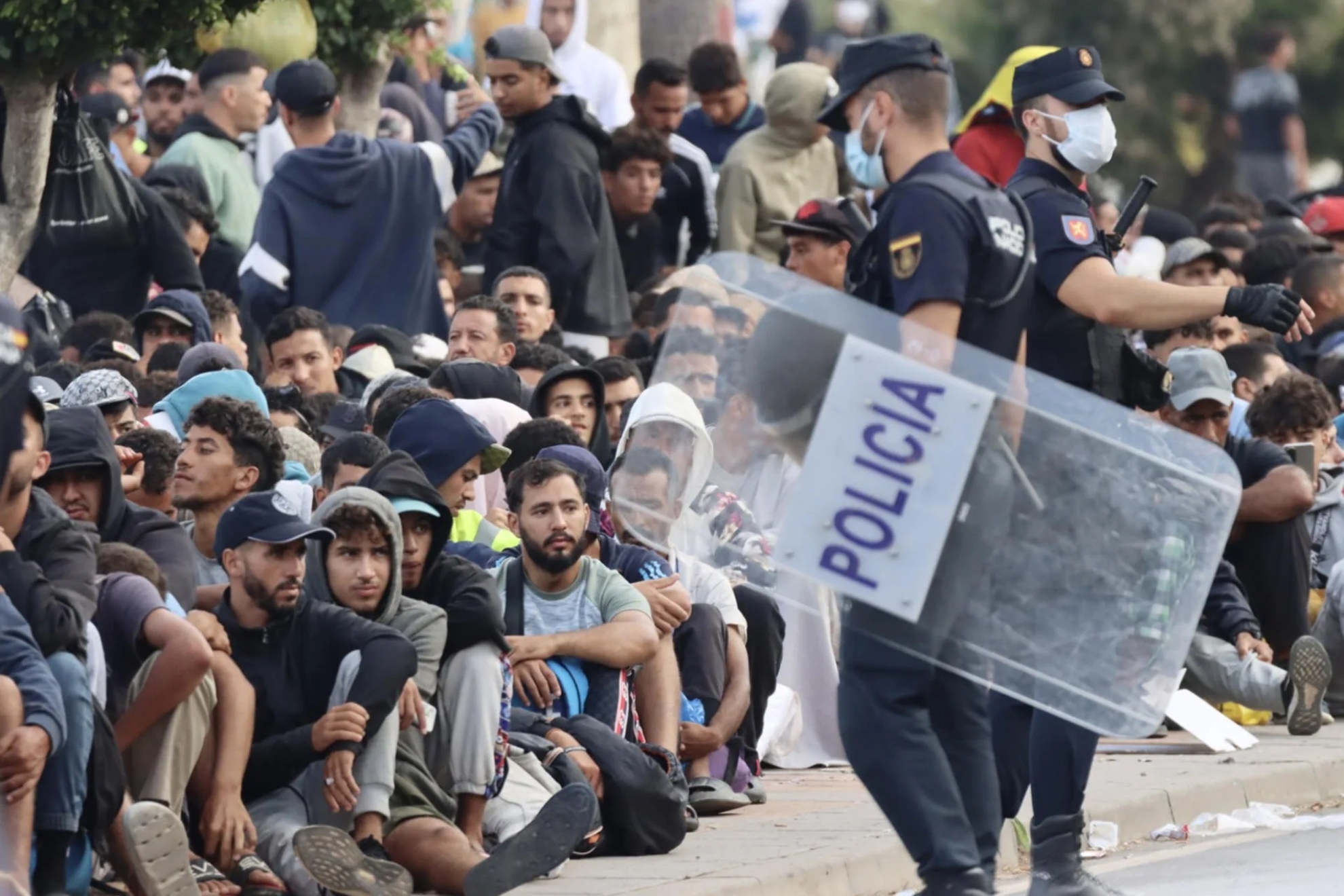 Imagen de recurso de un agente y varios migrantes en Ceuta. EFE