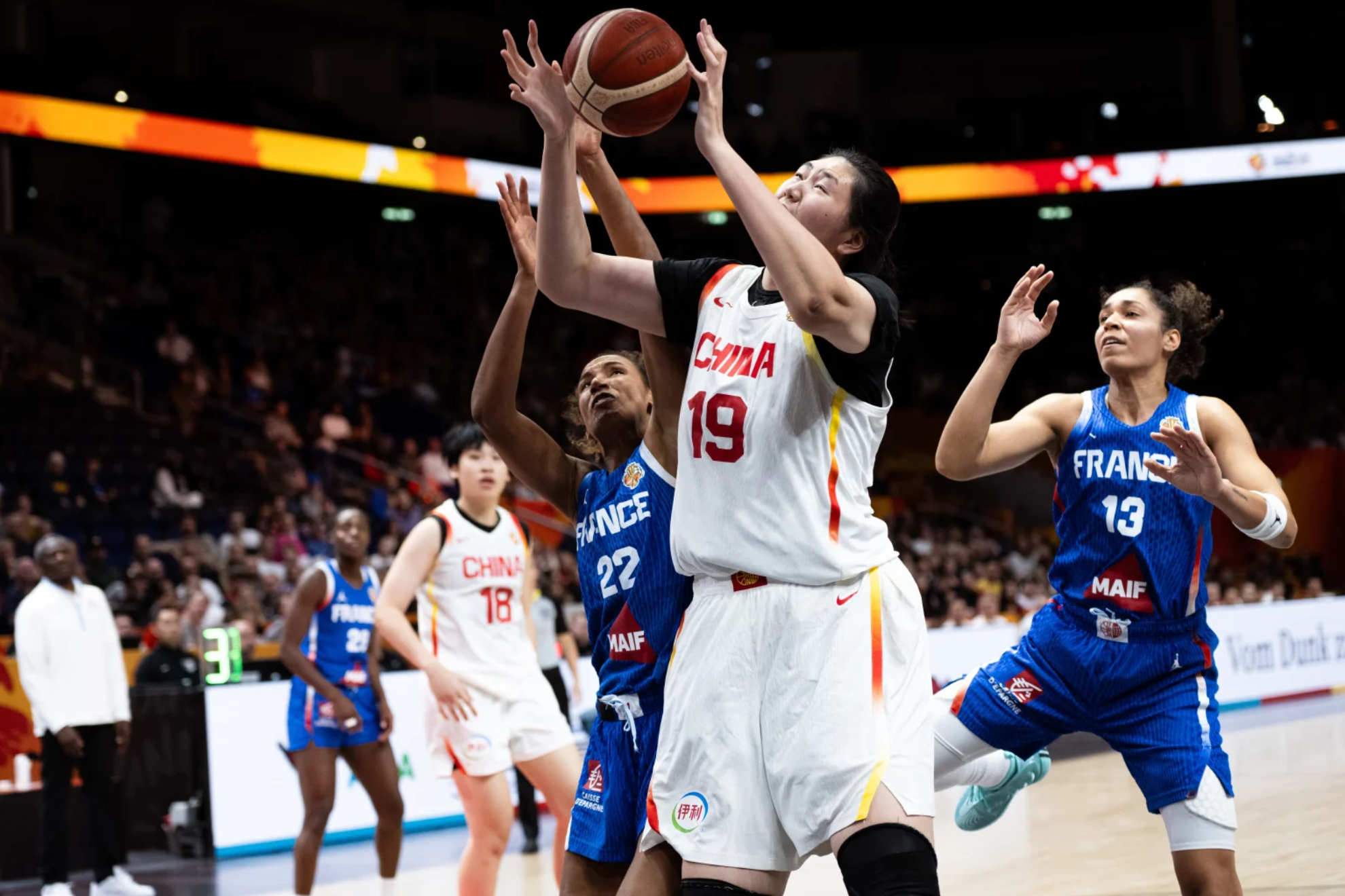 Ziyu Zhang trata de anotar ante la defensa de Francia. FIBA PHOTO.