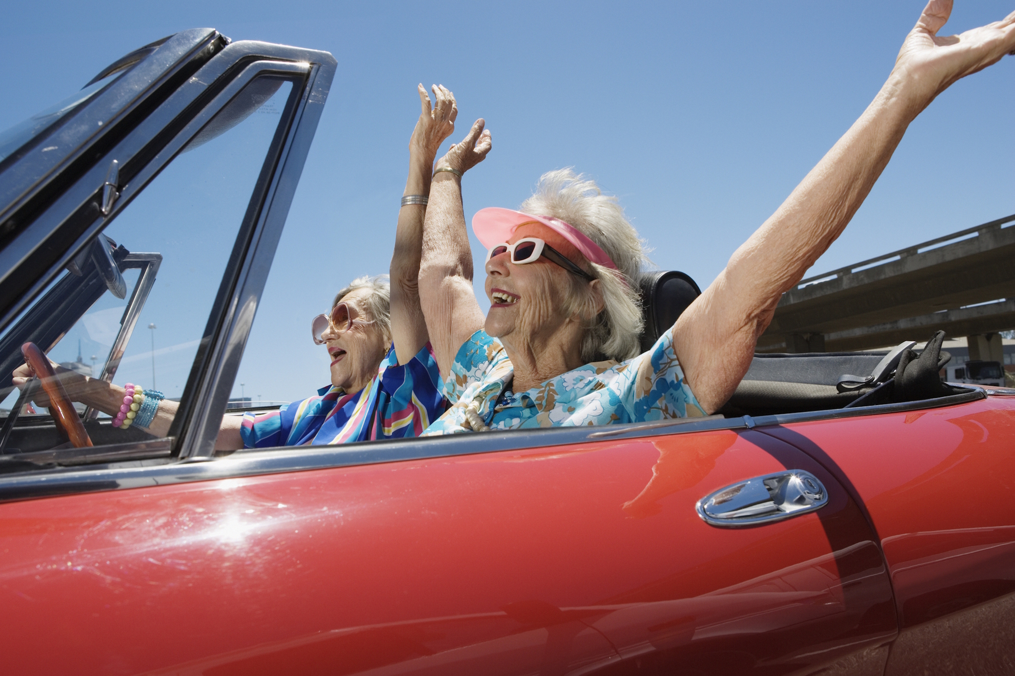 Dos mujeres disfrutan en un coche. Getty